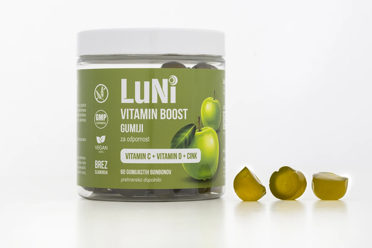 Embalaža Luni Vitamin boost gumiji z vzorčnimi gumiji raztresenimi ob strani.